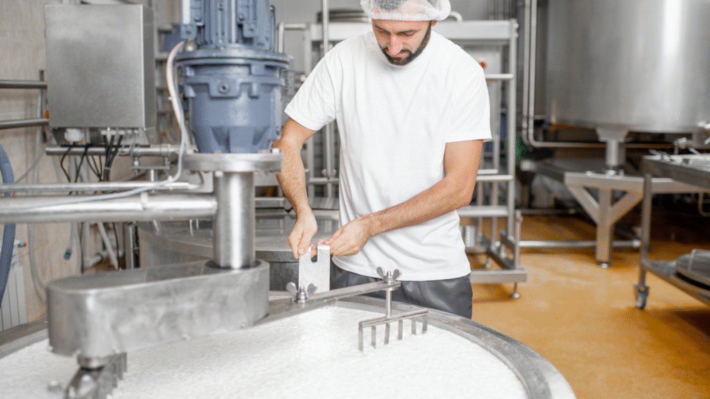 Almarai Jobs : Dairy factory worker operating equipment to process milk in a modern production facility – dairy industry jobs